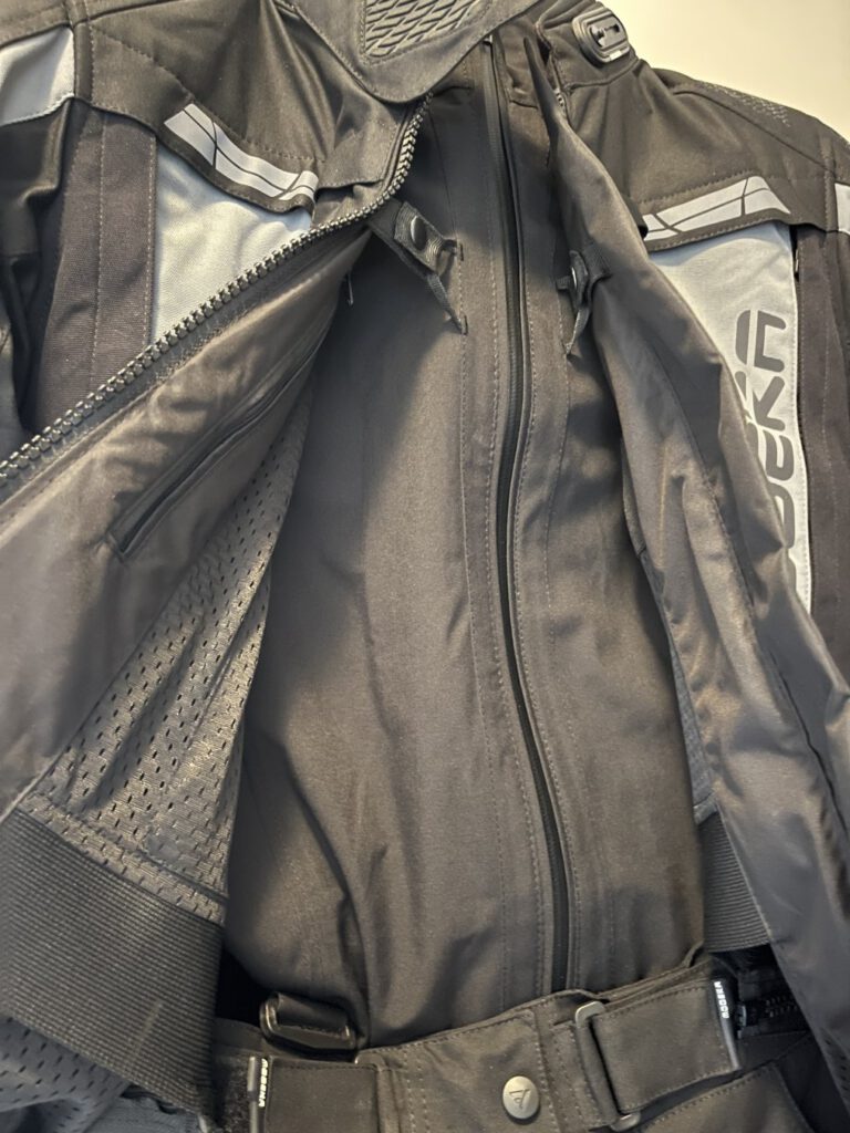 Die Regenjacke, oder auch Membran, hängt durch Druckknöpfe gesichert in der Außenjacke